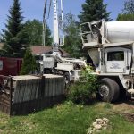 Pumping concrete for a new addition on an existing home. The pump snorkel reaches over the house.